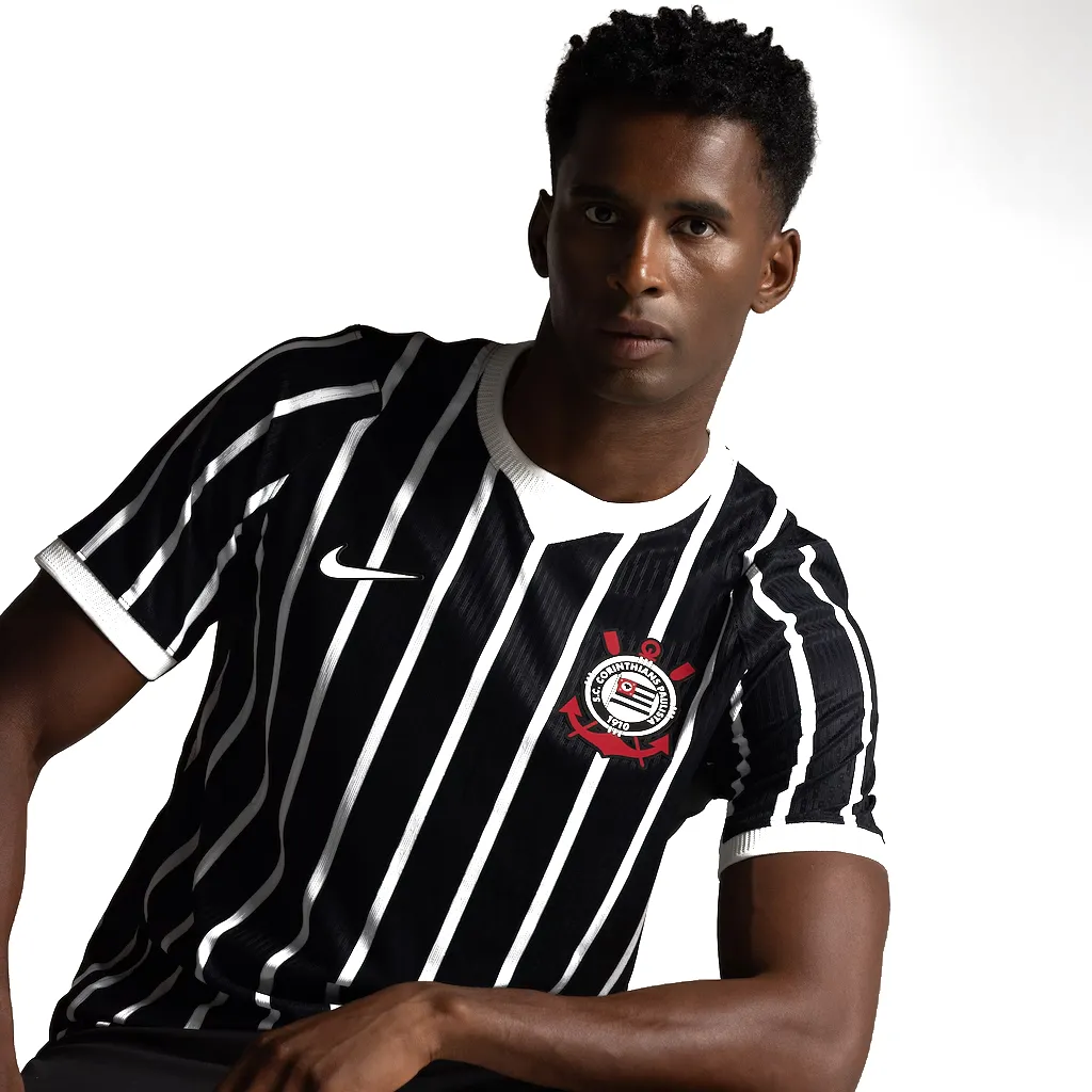 Modelo sentado vestindo a camisa, em close.