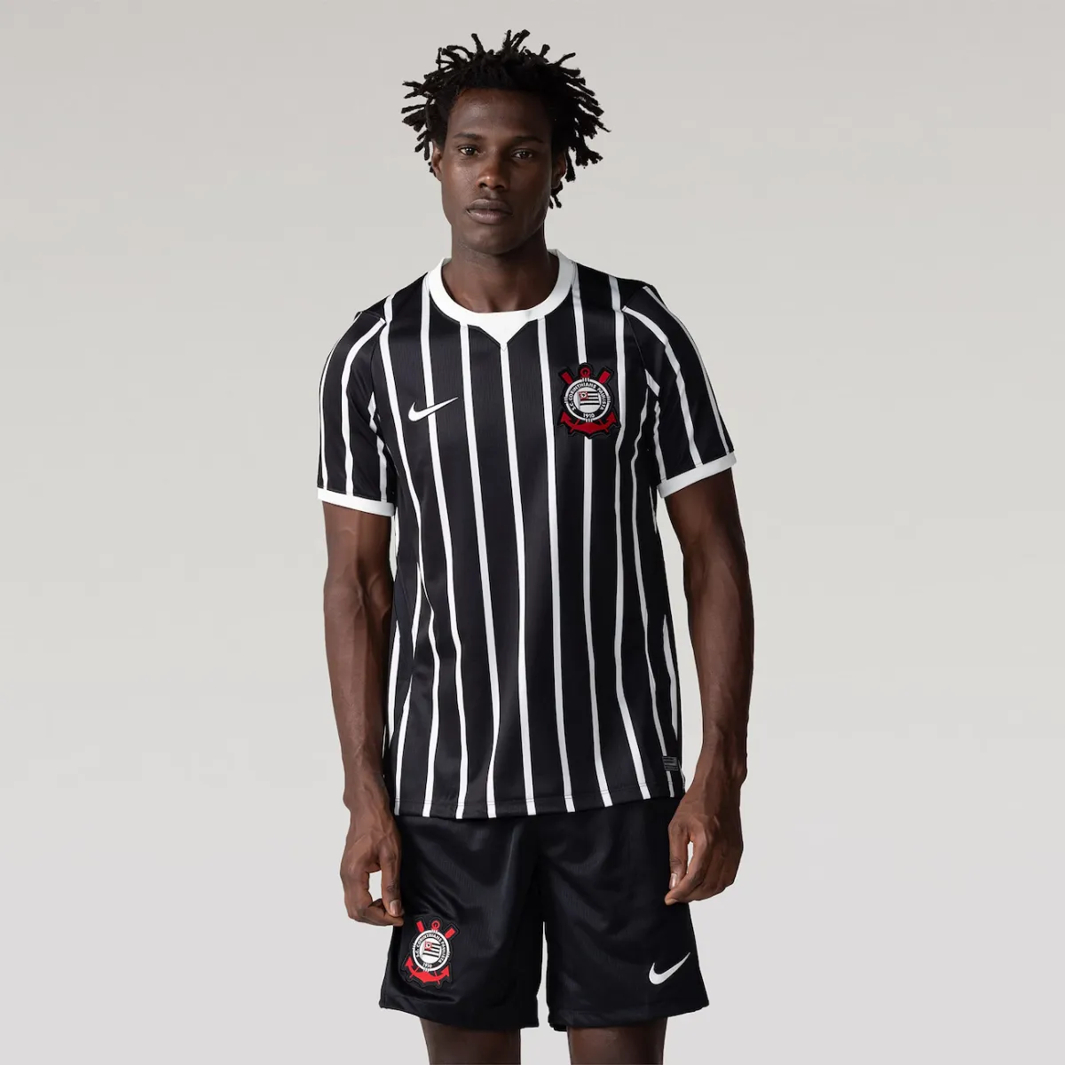 Modelo vestindo a camisa do Corinthians Away 26/27, vista frontal de corpo inteiro.